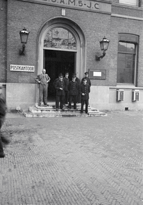 853233 Afbeelding van enkele postbodes voor de als postkantoor in gebruik zijnde Gemeentelijke Hogere Burgerschool A ...